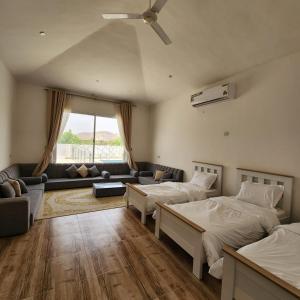 DawwahにあるWadi Bani Khalid - Al Joud Green Hostelのリビングルーム(ベッド2台、ソファ付)
