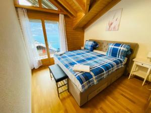 ein Schlafzimmer mit einem Bett in einem Zimmer mit einem Fenster in der Unterkunft LakeSide Villa - 18 in Niederried