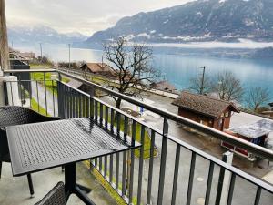 einen Balkon mit einem Tisch und Seeblick in der Unterkunft LakeSide Villa - 18 in Niederried