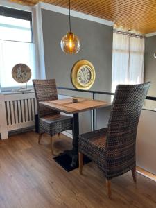 uma sala de jantar com uma mesa e duas cadeiras em fichtel.flat em Mehlmeisel