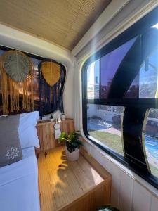 MAKTUB PREA HOSTEL في بري: غرفة القطار مع طاولة و نافذتين