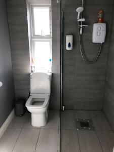 a bathroom with a toilet and a shower with a window at Private entrance studio , garden and free parking in Slough