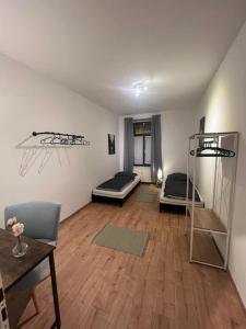 een woonkamer met 2 bedden en een houten vloer bij Lichtung Appartement - *WLAN**Netflix**Stadion-Nah* in Leipzig