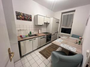 una pequeña cocina con mesa y silla azul en Lichtung Appartement - *WLAN**Netflix**Stadion-Nah* en Leipzig