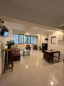 a large living room with couches and tables at Cinnamon House in Pune