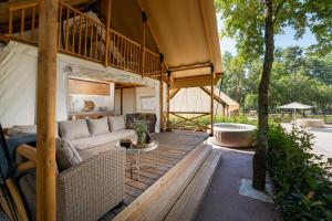 an outdoor living room with a couch and a table at Banki Green Istrian Village - Holiday Homes & Glamping Tents in Bašići