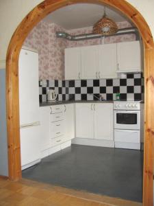 an archway into a kitchen with white cabinets at Economy Baltics Apartments - Liivamäe in Tallinn