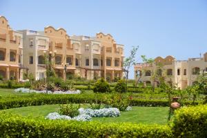 a garden in front of a large building at Concorde Moreen Beach Resort in Abu Dabbab