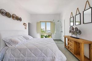 een witte slaapkamer met een groot bed en een houten tafel bij Pyrgos terracevilla in Pirgos