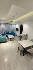 فندق جرين ليف في جدة: غرفة معيشة مع الأرائك الزرقاء والطاولات