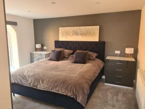 a bedroom with a large bed and two night stands at The Granary in Buckley