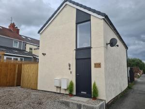 a small house with a black door on a street at The Granary in Buckley