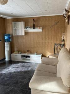 a living room with a couch and a refrigerator at EL RECOVECO DE MIRA in Mira