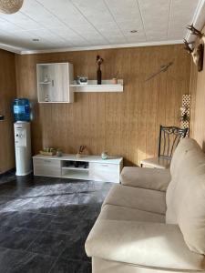 uma sala de estar com um sofá e um frigorífico em EL RECOVECO DE MIRA em Mira