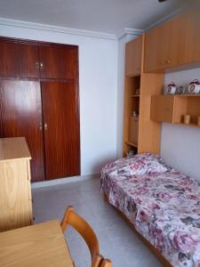 Schlafzimmer mit einem Bett, einem Tisch und einem Schreibtisch in der Unterkunft Policarpo-centro in Torrevieja