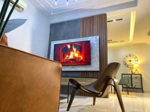 a fireplace in a living room with a chair at Luxury 2-Storey Terrace House near IOI City Mall Putrajaya in Putrajaya