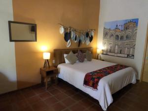 Cette chambre comprend un lit et une télévision. dans l'établissement Hotel Boutique Sol y Luna SPA, à Ajijic