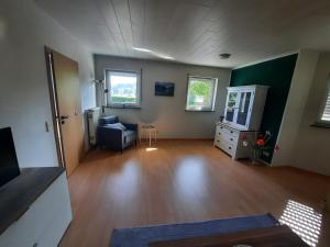 an empty living room with a couch and a dresser at Fewo Lerchi am Nürburgring in Kelberg