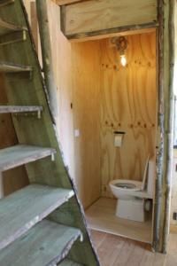 a bathroom with a toilet in a wooden house at Boomhut in Voorthuizen