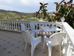 una mesa blanca y sillas en un balcón con vistas en Sunny Villa, en Ksamil