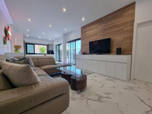 sala de estar con sofá y TV en Villa de lujo con piscina climatizada, en Mogán