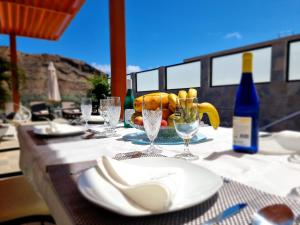 una mesa con platos y copas de vino. en Villa de lujo con piscina climatizada, en Mogán