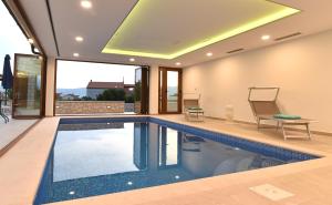 einen Pool in einem Haus mit einer Decke in der Unterkunft Villa Muskatel -with heated pool in Krk