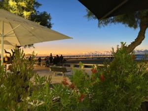 - un parc avec un banc et un parasol dans l'établissement Bonne Surprise, T3 terrasse pr. plage/ centre/gare, à Arcachon