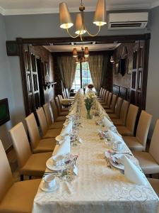 une grande table dans une pièce avec des chaises et une grande table dans l'établissement Hotel Kresowianka, à Konin