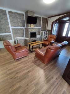 a living room with leather furniture and a fireplace at Карпатська Вершина in Yaremche