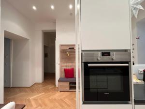 cocina con paredes blancas y fogones horno superior en Apartment with garden - central station, en Viena