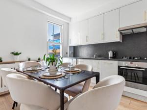 a kitchen with a table and chairs in a kitchen at Chelsea Maisonette in London