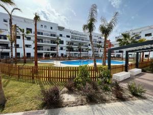 un complejo de apartamentos con piscina y palmeras en PUSHE Playa Granada Beach & Golf 15, en Motril