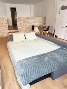 a large bed in a room with a brick wall at Loft coqueto en Madrid a 2 minutos del metro in Madrid