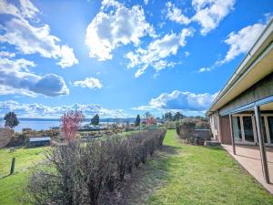 a house with a view of the water at Luxury Lake View farm stay with spa pool in Rotorua