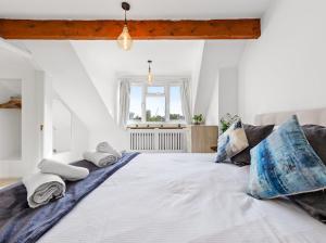 Un dormitorio con una cama grande con almohadas. en Chelsea Maisonette, en Londres
