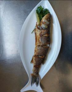 un plato blanco con un pedazo de pescado. en Turistično - Izletniška kmetija Žerjav, en Brežice