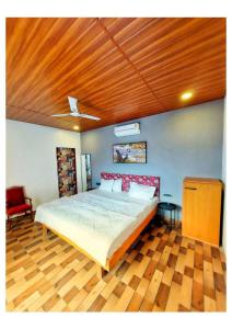 a bedroom with a large bed with a wooden ceiling at Knights Villa 5BHK in Chauk