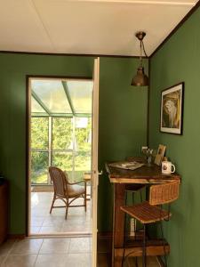 Zimmer mit grünen Wänden, einem Schreibtisch und einem Stuhl in der Unterkunft Gästehaus Zur Walnuss Berlin in Blankenfelde