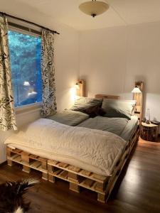 um quarto com uma cama feita de paletes em Gästehaus Zur Walnuss Berlin em Blankenfelde