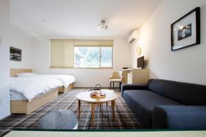 Sweet Stay Kyoto - Vacation STAY 21712v في كيوتو: غرفة معيشة مع سرير وأريكة