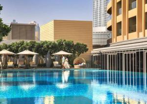 a woman walking by a swimming pool in a city at Fashion Avenue Dubai Mall in Dubai +45 photos