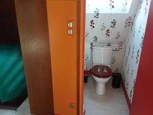 ein Bad mit einem roten WC in einem Zimmer in der Unterkunft Ty Eflenn in Locunolé