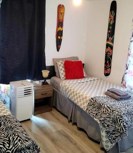 1 dormitorio con 2 camas y mesa con mesita de noche en Quiet cozy apartment next to highway wifi+netflix, en Edmundston