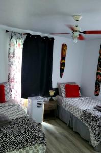 1 dormitorio con 2 camas y ventilador de techo en Quiet cozy apartment next to highway wifi+netflix, en Edmundston
