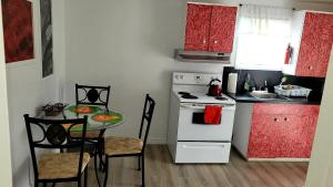 a small kitchen with a table and a white stove at Quiet cozy apartment next to highway wifi+netflix in Edmundston