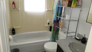 a bathroom with a tub and a toilet and a sink at Quiet cozy apartment next to highway wifi+netflix in Edmundston