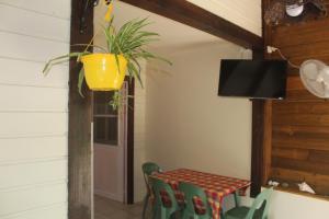 ein Esszimmer mit einem Tisch und einer Topfpflanze in der Unterkunft Gite bagatelle classé 2 étoiles in Sainte-Rose