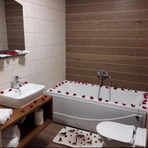 La salle de bains est pourvue d'une baignoire, de toilettes et d'un lavabo. dans l'établissement Hotel Rafaelo, à Bosanska Dubica