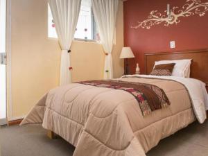 sypialnia z dużym łóżkiem z czerwoną ścianą w obiekcie Hotel Andean Host Inn w Cuzco
